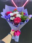 Букет из малиновых роз, синих ирисов и хризантем с добавлением гиперикума   в лавандовом оформлении